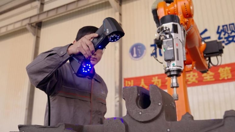 An engineer using the handheld 3D scanner directly on the production line.-1